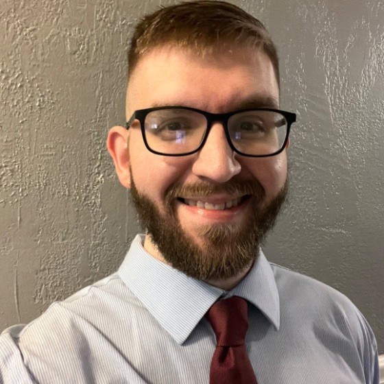 Bookkeeper with glasses smiling in New Braunfels, TX office.